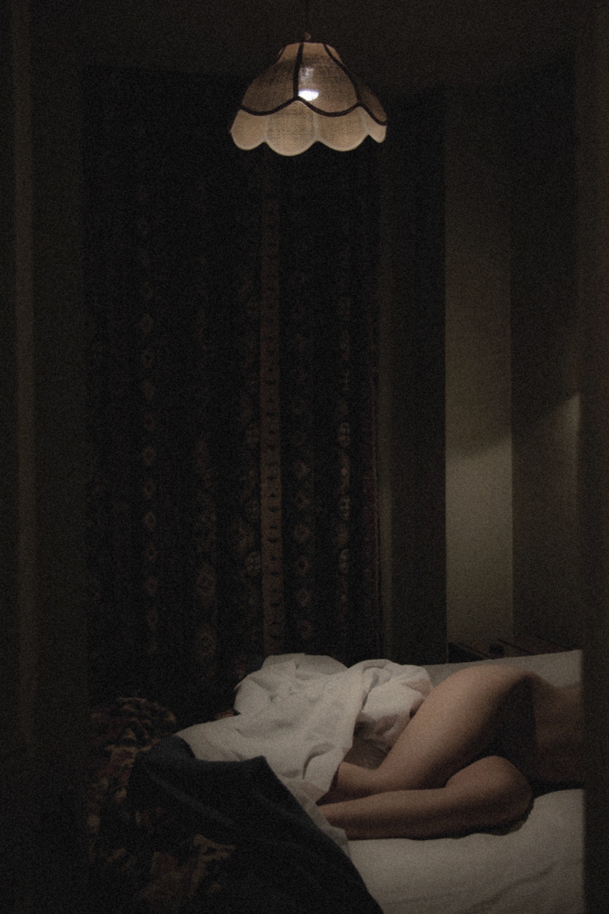 Figure resting in a dark room